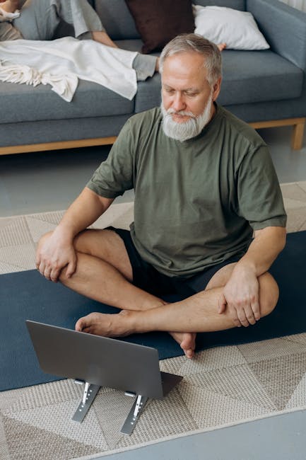 Person in comfortable clothes stretching gently on a yoga mat in a home environment.